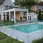 Frameless glass pool railing around a modern backyard pool