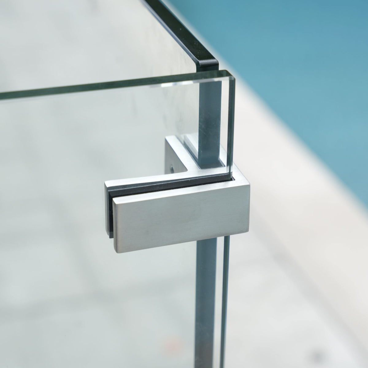 Engineered glass railing spigot installed on a deck, part of a certified frameless glass railing system with stamped engineering documents