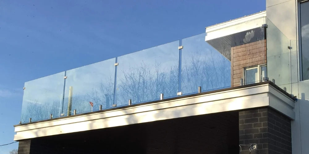 Frameless glass balcony railing on a modern home exterior