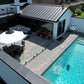 Aerial view of a frameless glass pool fence beside a patio dining area and lounge