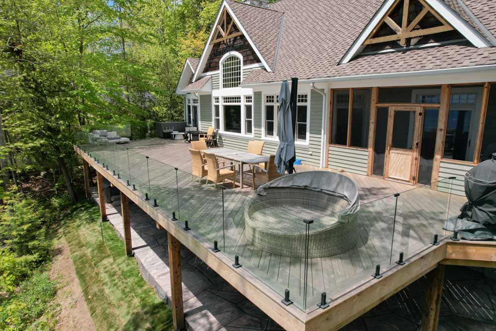 Frameless glass railing with stainless steel base shoe along a modern deck