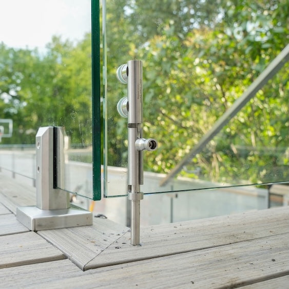 Floor lock securing a frameless glass pool fence gate into the ground