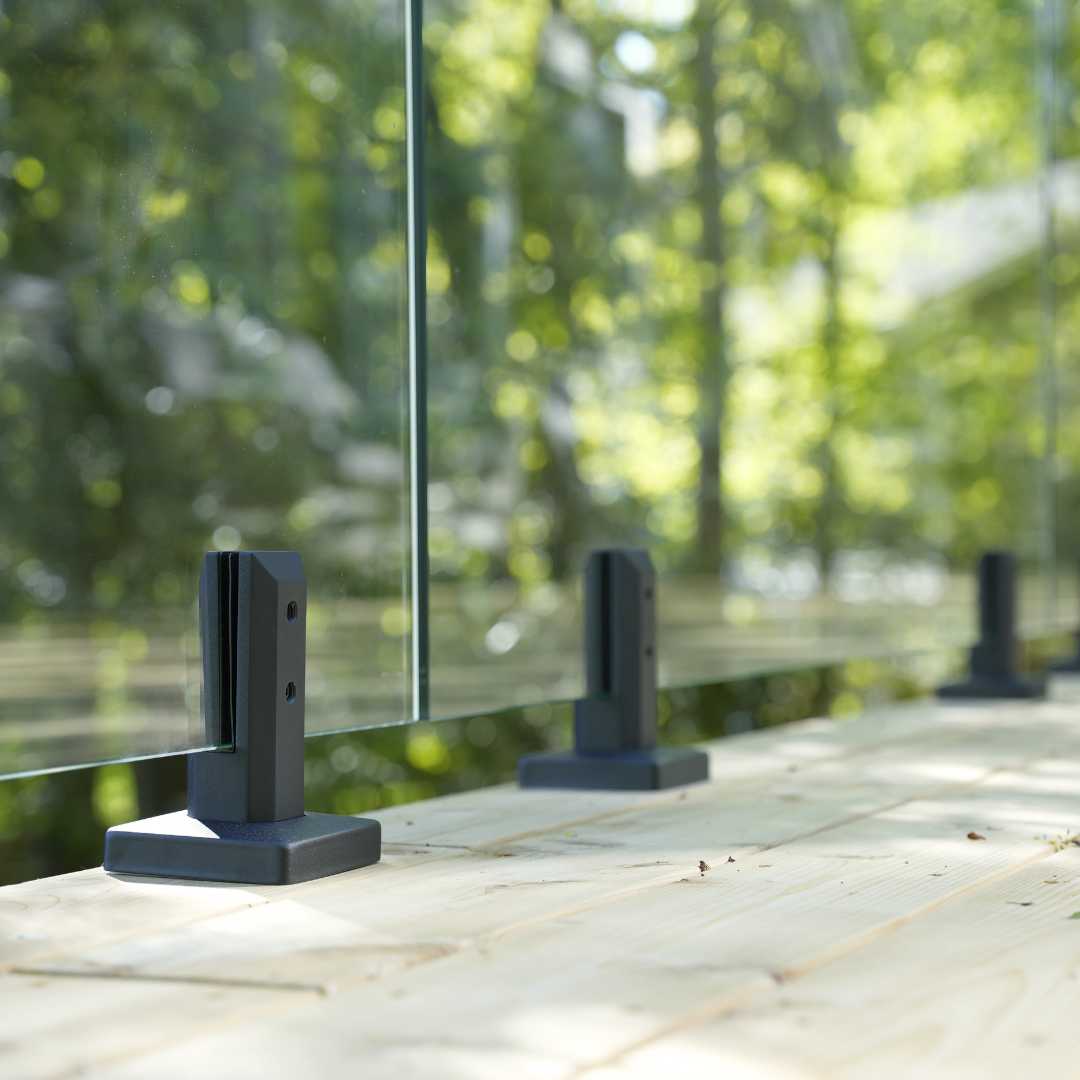 Brushed stainless steel glass railing spigot mounted on a deck