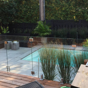 frameless glass railing installed around pool side for clear view and safety